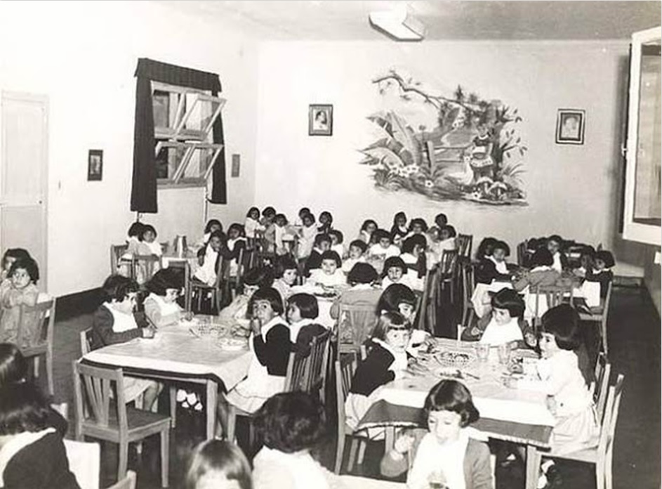 Foto en blanco y negro de un grupo de personas en un salón

Descripción generada automáticamente